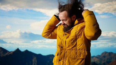 Genç gezgin dağların zirvesinde soğuk hava ve rüzgarla uğraşırken kişisel başarısıyla gurur duyuyor. Doğa aşığı kötü hava koşulları nedeniyle tırmanmaya çalışır. Kamera A.