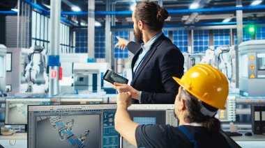 Yönetici, güneş panelleri fabrika çalışanına yerleşim planlarını optimize etmek için CAD yazılımının nasıl kullanılacağı konusunda talimat veriyor. Fotovoltaik fabrikası yöneticisi işçilere maksimum enerji çıkışı için nasıl düzenlemeler yapılacağını öğretiyor, kamera A