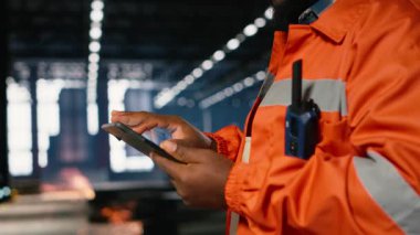 Metal otomasyon araçlarını inceleyen siyah erkek teknisyen profesyonel mühendislik için montaj görevlerini temsil ediyor. Üretim iş akışı endüstriyel imalat için gereklidir. Kamera B.