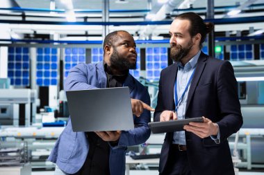 Çeşitli mühendislerden oluşan bir ekip, sürdürülebilir kalkınma üzerine yoğunlaşarak, modern bir endüstriyel fabrikada güneş enerjisi performansını değerlendiriyor. Sürdürülebilirlik için yenilenebilir güç.