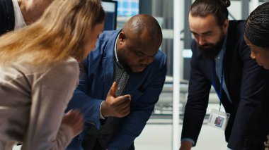 Fabrika mühendisleri güneş paneli montaj hatlarının ayrıntılı şemalarını inceleyerek, tablet kullanarak üretim planlarını rafine ediyorlar. Endüstriyel fabrika uzmanları yeni prototipler için yapılandırmaları özetliyor, kamera B