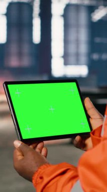Tablet ve modern makineler kullanarak imalat ve imalat işleriyle uğraşan mühendislerle birlikte dikey video krom anahtar, güçlü insan gücünü gösteriyor. Endüstriyel operasyon. Kamera B.