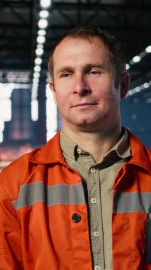 Teknisyenin dikey video portresi, atölyedeki üretim sırasında metal üretimini denetleyerek ağır işçiliğin altını çiziyor. Otomasyon geliştirme ve üretim tesisi içindeki iş sorumlulukları