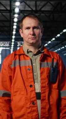 Çelik makineler ve insan gücü ile çevrili endüstriyel fabrikadaki kaynak faaliyetlerini denetleyen mühendislerin dikey video portresi. Modern imalat için endüstriyel ortam şart