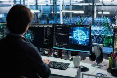 Veri merkezi mühendisi PC kullanarak, AI model parametrelerini doğruluğu arttırmak için ayarlıyor. Sunucu merkezi çalışanı, donanım bileşenleri için yapay zeka programı hazırlıyor.