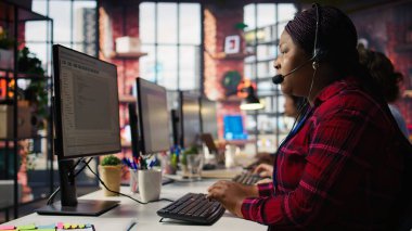 Ofisteki bilgisayar uzmanı. Çağrı sırasında müşterilere yardım ediyor. Sorun çıkarma hataları. Masada bilgisayar monitörüne bakan teknik destek ajanı, müşteriler için teknik sorunları düzeltiyor, kamera B