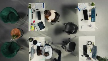 İş görüşmeleri sırasında iş görüşmelerine katılan çalışma ekibinin yukarıdan aşağı zoom 'u. Çalışanlar, ofisteki mali verileri ve performans raporlarını analiz etmek için dizüstü bilgisayar kullanırlar. Kamera A.