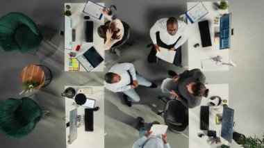 Yukarıdan aşağıya, bir toplantıda hedef ve hedefleri tartışan çalışanların görüntüsünü büyüt. Şirket çalışma ekibi iş tahminleri için dosyaları, verileri ve performans ölçümlerini inceliyor. Kamera A.