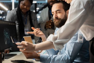 Bilgisayar kullanarak veri merkezindeki yazılım geliştiricileri, güvenlik duvarı yapılandırmalarını doğruluyor. İş arkadaşları beyin fırtınası yapıyor, bilgisayar kullanarak sunucu odasında ekipman kırılganlığı taraması yapıyor.