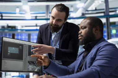 Diverse team of male professionals working together in a high tech factory, sharing their expertise to ensure efficient production of clean energy. Managing photovoltaics manufacturing.