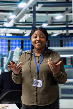 Solar Tech danışmanı güneş enerjisi üretimiyle ilgili bir tartışmayı güvence altına alıyor, çalışanlara yenilenebilir enerji verimliliğini güvence altına almaları için brifing veriyor. Bir imalat fabrikasında iş danışmanı.