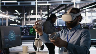 VR kulaklık kullanarak AI LLM görüntülemesini izleyen bir veri merkezi teknisyeni. Sanal gerçeklik teknolojisini kullanarak sunucu odası çalışanı, sondaj makinelerinin öğrenme süreçlerini denetliyor, kamera A