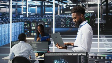 Veri merkezi sistem yöneticisi düğüm ağacı araçları kullanarak altyapı sorunlarını analiz ediyor. Sunucu merkezindeki adam, sistem sağlığını optimize etmek için yapay zeka görselleme bilgilerini kullanıyor. Kamera A.