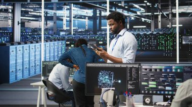 Veri merkezi teknisyeni tablet kullanarak düğüm ağacı programlama ve kaynak tahsisini optimize ediyor. Sunucu odası bilişim uzmanı bakım planlama için öngörücü yapay zeka görselleştirme sistemleri kullanıyor, kamera A