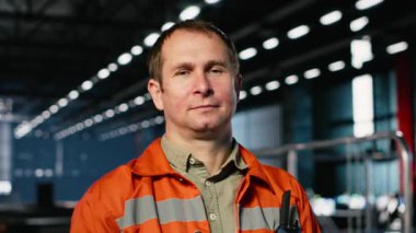 Teknisyen portresi, atölyedeki üretim sırasında ağır işçiliğin altını çizerek metal imalatını denetliyor. Otomasyon geliştirme ve üretim tesisinde iş sorumlulukları. Kamera B.