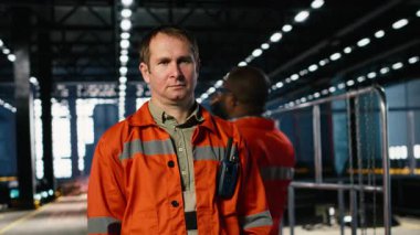 Endüstriyel atölyedeki kaynak makinelerini denetleyen teknisyen işgücü, metal üretimi ve koruyucu teçhizat kullanımını vurguluyor. Üretim işlemi için ağır sanayi tesisi. Kamera B.