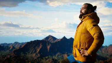 Yürüyüşçü, tepedeki panoramik dağ manzarasına, sonsuz gökyüzüne ve engebeli tepelere hayran olmak için durup zihinsel berraklık için nefes kesici bir zemin oluşturur. Maceraperest. Kamera A.