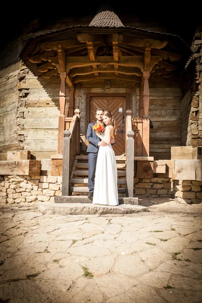 Pareja recién casada frente a la puerta de la iglesia — Foto de Stock