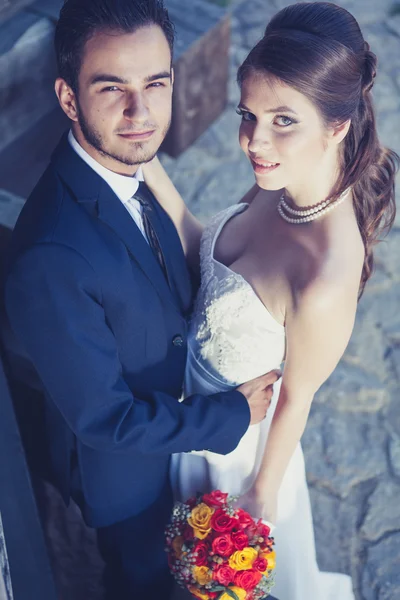 Groom and bride with bouqouet looking up — Stockfoto