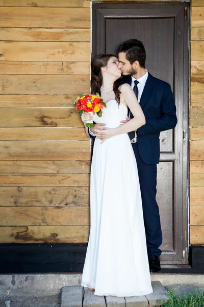Jovem apenas casado casal na frente da porta — Fotografia de Stock