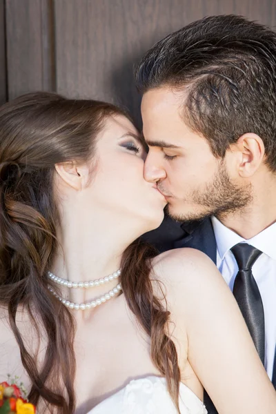 Nevěsta a ženich líbat navzájem — Stock fotografie