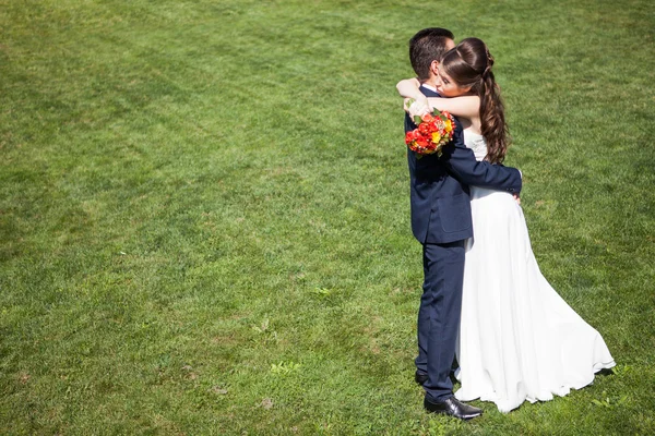 Femme en robe de mariée embrassant le mari — Photo