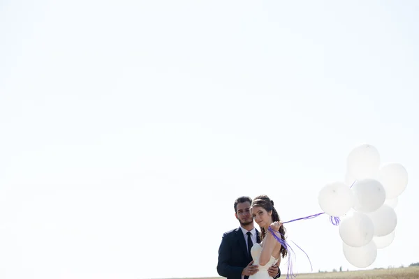 Girl in wedding dress and husbad with ballons in hands — 图库照片