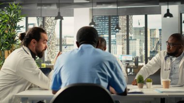 Sağlık uzmanları ve sağlık görevlileri konferans odasında işbirliği yapıyorlar. Sağlık personeli, kurul odasında takım çalışması ve iletişim yoluyla tedavi fikirleri ve sağlığıyla beyin fırtınası yapıyor..