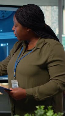 Yatırımcılar için sunum yapan dikey video teknisyeni açılışı yöneticisi toplantı odasında toplandı. Yapay zeka sektöründeki son yenilikleri sergileyen Afro-Amerikalı kadın kurumsal etkinliğin önünde