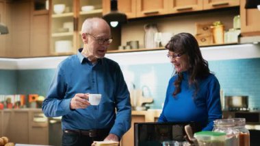 Yaşlı bir çift, evde sabah rutini için sağlıklı bir kahvaltı hazırlıyor. Olgun karı koca gündelik sohbetlerini paylaşıp, evde olumlu anlar yaratıyorlar. Kamera B.