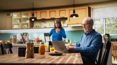 Mutsuz yaşlı adam dizüstü bilgisayarda hayal kırıklığı yaratacak yeni bir şey buluyor, yaşlı karısı onu teselli ediyor ve destekliyor. Kahvaltı masasında kahve servisi yapan çift. Kamera A.