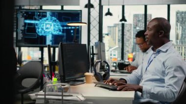 Yapay zeka ile başlayan ofis personeli bilgisayardaki sinirsel ağları kullanarak iş akışlarını otomatikleştiriyor. Afrikalı Amerikalı adam ve takım lideri daha hızlı işlem için derin öğrenme modellerini geliştirdiler, kamera B