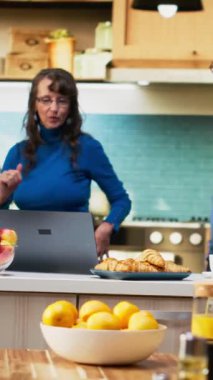 Dikey Video Neşeli Hayat Arkadaşları mutfakta eğlenceli bir sabah dansının tadını çıkarıyor, emekliliklerinin tadını çıkarıyorlar. Harika hareketler sergileyen evli insanlar, olumlu davranışlarına gülüyorlar ve şefkat gösteriyorlar.