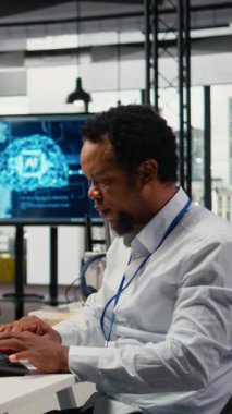 Yapay Zeka 'da çalışan dikey bilgisayar bilimcisi dil işleme görevleri için öngörücü modeller eğitiyor. Afrikalı Amerikalı adam karmaşık bilişim için makine öğrenme teknik uzmanlığını kullanıyor