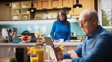 Mutfakta gülümseyen ve sıcak içkinin keyfini çıkaran son sınıf kadınının portresi. Emekli hayatın doğal portresi huzurlu yaşam tarzını ve evdeki konforu yakalar. Kamera A.