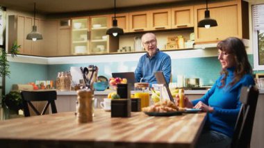 Olgun yaşlı bir adam, sakin bir mutfak anındaki dizüstü bilgisayarında kahve fincanıyla internete girip emeklilikteki rahat yaşam tarzını ön plana çıkarıyor. Huzurlu bir yaşam ve doğal bir ev hayatı. Kamera A.