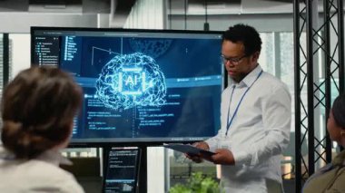 Girişimcilik ofisinde CTO ilgili yatırımcılara derin öğrenme teknolojisi sunumu yapıyor. IT uzmanı iş yatırımcılarına en son yapay zeka teknolojisi yeniliklerini göstermek için ekranı kullanıyor, kamera B