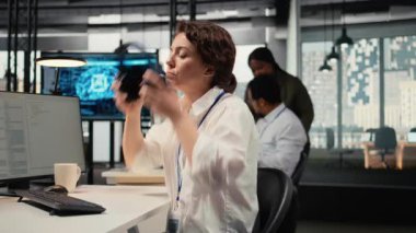 Ofisteki stresli programcı kompleks yapay zeka hesaplamalarıyla çalışırken dinlenmek için müzik dinliyor. Yorgun bilişim çalışanı ses kulaklığı takıyor, derin öğrenme sistemleri eğitiyor, kamera A