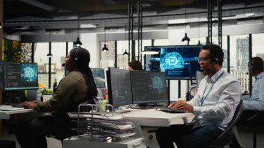 Uzaktan arama sırasında kullanıcıların hataları düzeltmesine yardımcı olan teknik destek yapan başlangıç programcıları. İş yerindeki yardım görevlileri mikrofonla konuşuyor, servis alarmlarına cevap veriyor, müşterilere yardım ediyor, kamera A