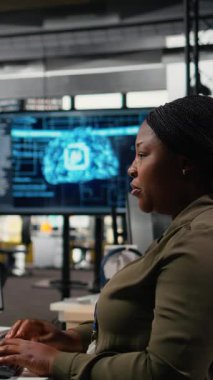 Dikey video teknisyenleri ofiste beyin fırtınası yapıyorlar, karmaşık yapay zeka hesaplamalarını hızlandırmak için özel donanım kullanıyorlar. Makine öğrenme eğitimi sistemlerini yöneten takım arkadaşları