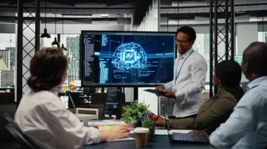 Girişimcilik ofisinde CTO ilgili yatırımcılara derin öğrenme teknolojisi sunumu yapıyor. IT uzmanı iş yatırımcılarına en son yapay zeka teknolojisi yeniliklerini göstermek için ekranı kullanıyor, kamera A