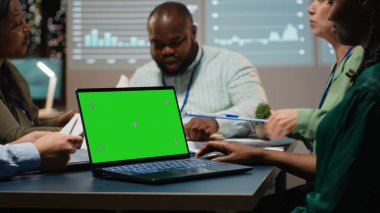 Çeşitli proje çalışanları gece ofiste dizüstü bilgisayarda kroma anahtarıyla çalışıyor, bir şirket alanında gece vakti yapılan bir toplantıda haber verme ve iş hedefleri belirleme konusunda işbirliği yapıyorlar. Kamera B.