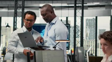 Ofisteki teknisyenler yeni özellikler başlatmak için yazılım geliştiriyorlar. Başlangıçta bilgisayar programları yazan, kod testi ve kalite güvencesi yapan iş arkadaşları, kamera B