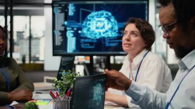 Yapay zeka şirketi yöneticileri brifing sırasında teknik yol haritasını tartışıyorlar. Veri bilimcileri derin öğrenim kullanarak uygulamalar geliştiriyor, şirket sistem ölçümlerini nasıl geliştireceklerine dair beyin fırtınası yapıyorlar, kamera A