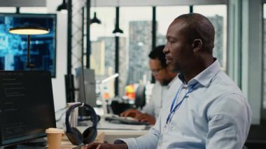 Veri bilimciler ofiste beyin fırtınası yapıyorlar, karmaşık yapay zeka hesaplamalarını hızlandırmak için özel donanım kullanıyorlar. Bilgi İşbirliği yapan, derin öğrenim veri sistemleri yöneten bilişim uzmanları, kamera B