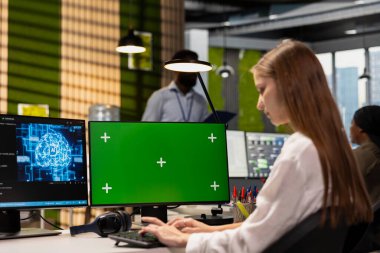 Kadın mühendis yeşil ekran bilgisayar kullanarak uygulamalar geliştiriyor, yapay zekayı ofis sistemlerine entegre ediyor. İşçi Krom anahtar PC kullanarak hata ayıklama uygulamalarında staj yapıyor