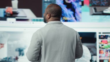 Mutluluğu ifade eden, sonsuz eğlence videolarının tadını çıkaran, video duvarına bakan mutlu bir adamın yakın çekimi. Neşeli Afro-Amerikan izleyicileri sonsuz yayın seçeneklerinin tadını çıkarıyor.