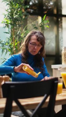 Ekmek kızartma makinesi ve ev yapımı yemekle kahvaltı servisi yapan Dikey Video Üst Düzey Yaşlılar, evde huzurlu bir sabah rutini paylaşıyorlar. Emeklilik çağında kahkahalarla ve gündelik sohbetlerle sıcak bir an. Kamera.