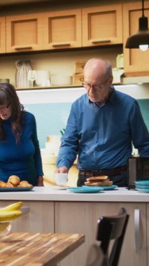 Dikey Video Yaşlı evli insanlar romantik aşk şarkısıyla vals yapıyorlar ve ömür boyu süren tutkuya minnettarlıklarını gösteriyorlar. Gülümseyen karı koca el ele tutuşuyor, yavaş dans ediyor, sallanıyorlar. Tatlı dans