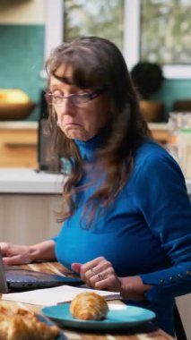 Dikey Video sunucusu evli çift ders kitabına alışveriş listesi yazıyor. Temel ihtiyaçlar, bakkaliye ve ev ürünleri için alışveriş listesi hazırlayan erkek ve kadın.